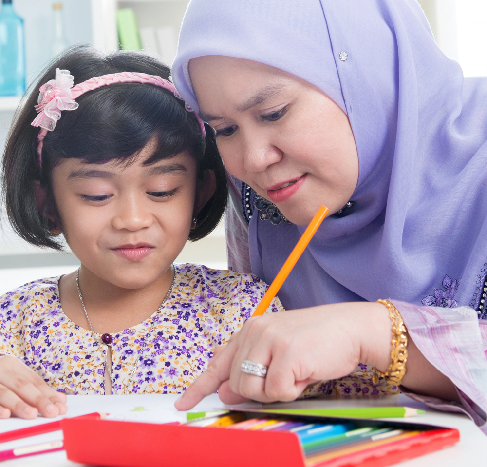 A teacher working with a very young learner