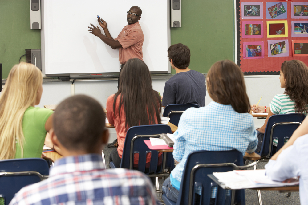 A teacher using an interactive whiteboard in class.
