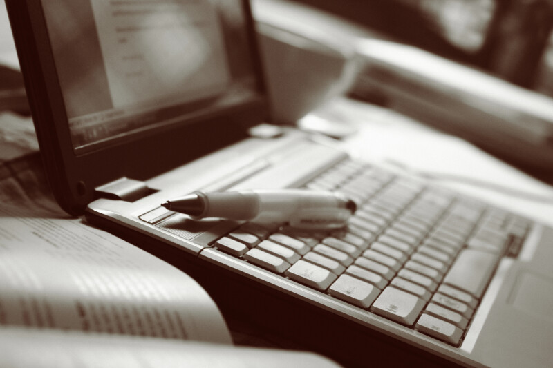laptop with a pencil next to a book for a writer to use for reference